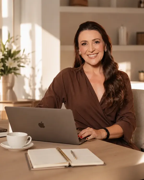 Glaucia Chignolli sorrindo em frente ao notebook